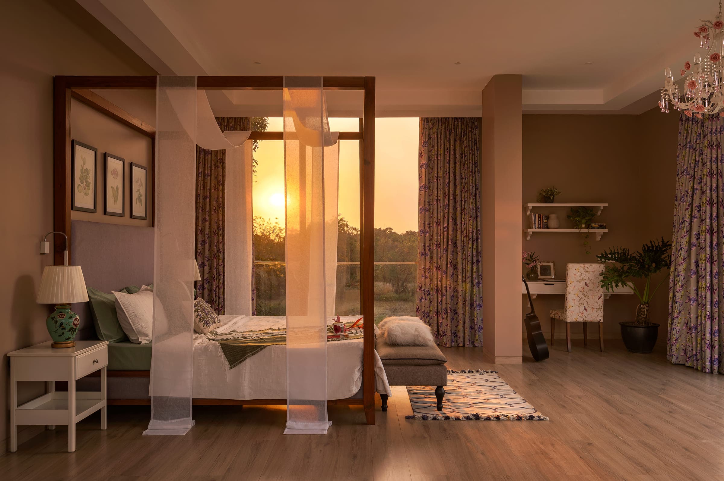 A bedroom at sunrise, the low sun coming through sheer curtains drawn around a timber four-poster bed.