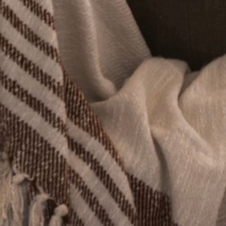 A woven throw and linen upholstery in soft neutral tones.