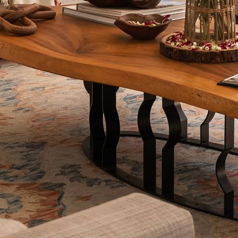 The live edge of the coffee table cut from a single log, above the patterned carpet.