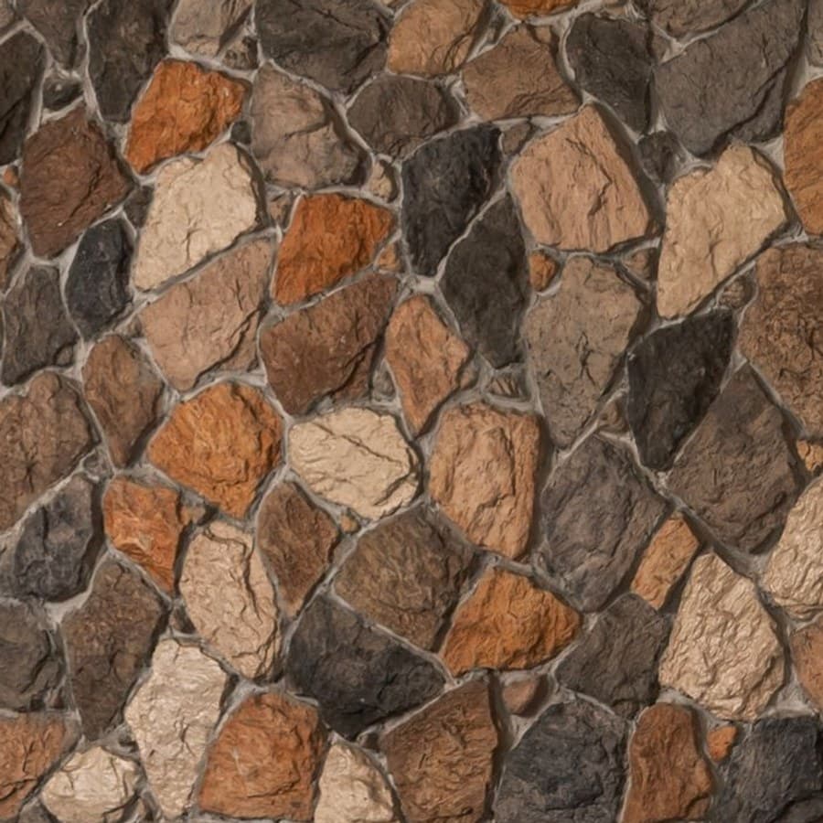 Close view of the rough-cut stone wall behind the dining table, in ochre, grey and cream.