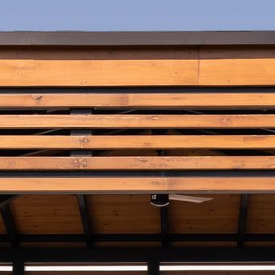 Close view of the warm timber slats forming the pergola roof.