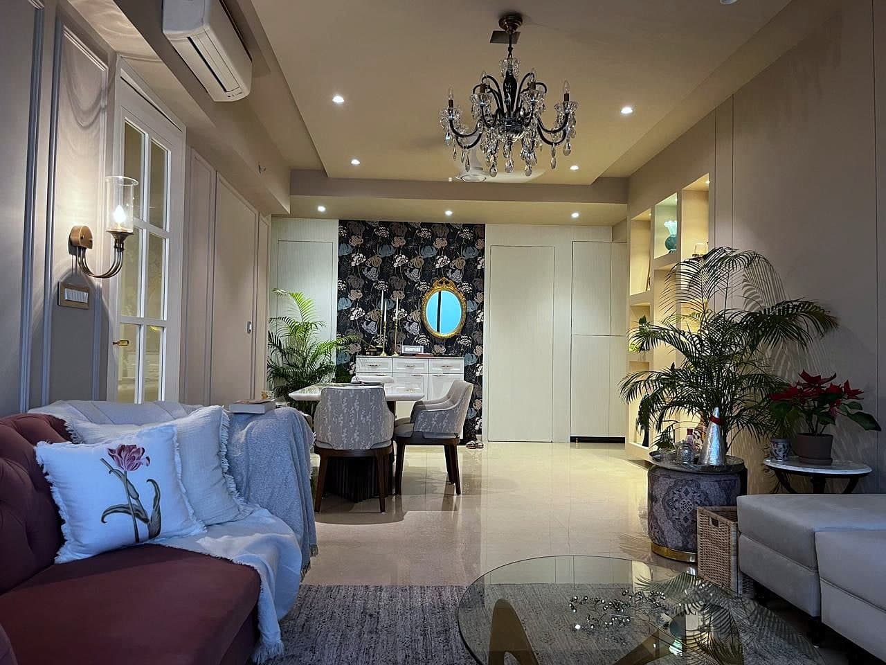 The view through to the dining end, the dark floral wall and gilt mirror at the far side, seating in the foreground.